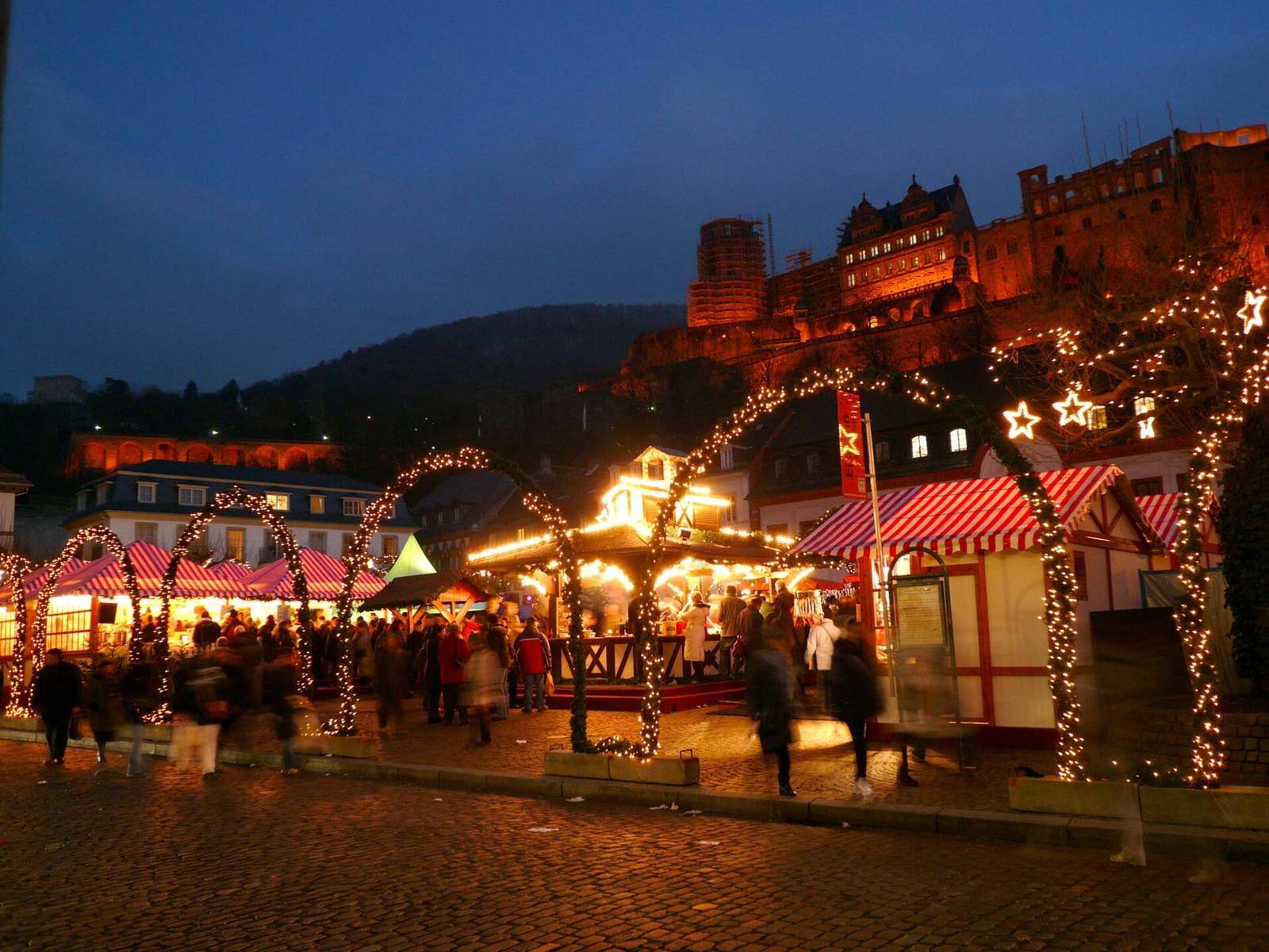 Heidelberger Weihnachtsmarkt am Abend unterhalb des beleuchteten Schlosses